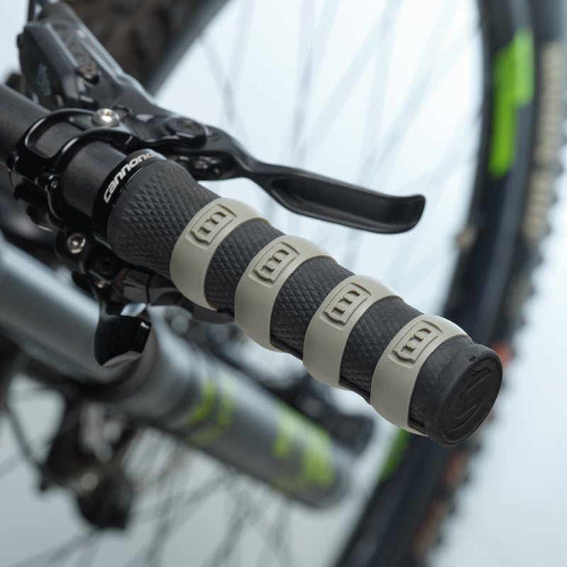 Close-up of a bicycle handlebar with gray Mint Sport silicon rings (aka SiliGrip Ringz) against a blurred background