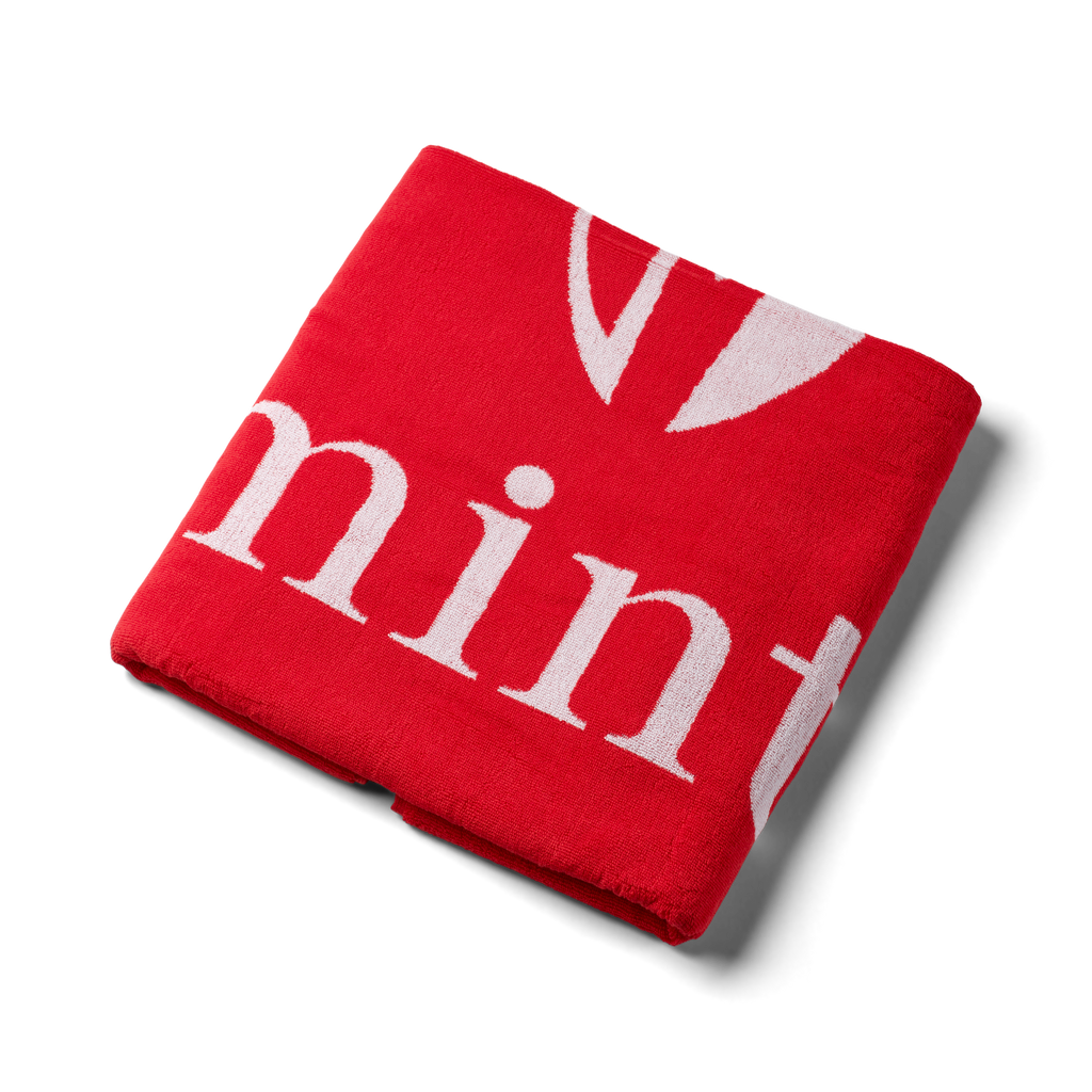 Red jacquard towel on a white background.