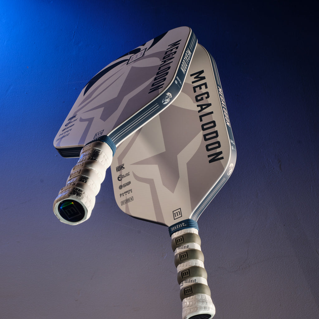 Mint Sport pickleball paddle with 'Megalodon' branding on a blue background.