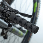 Close-up of a bicycle handlebar with black Mint Sport silicon rings (aka SiliGrip Ringz) against a blurred background
