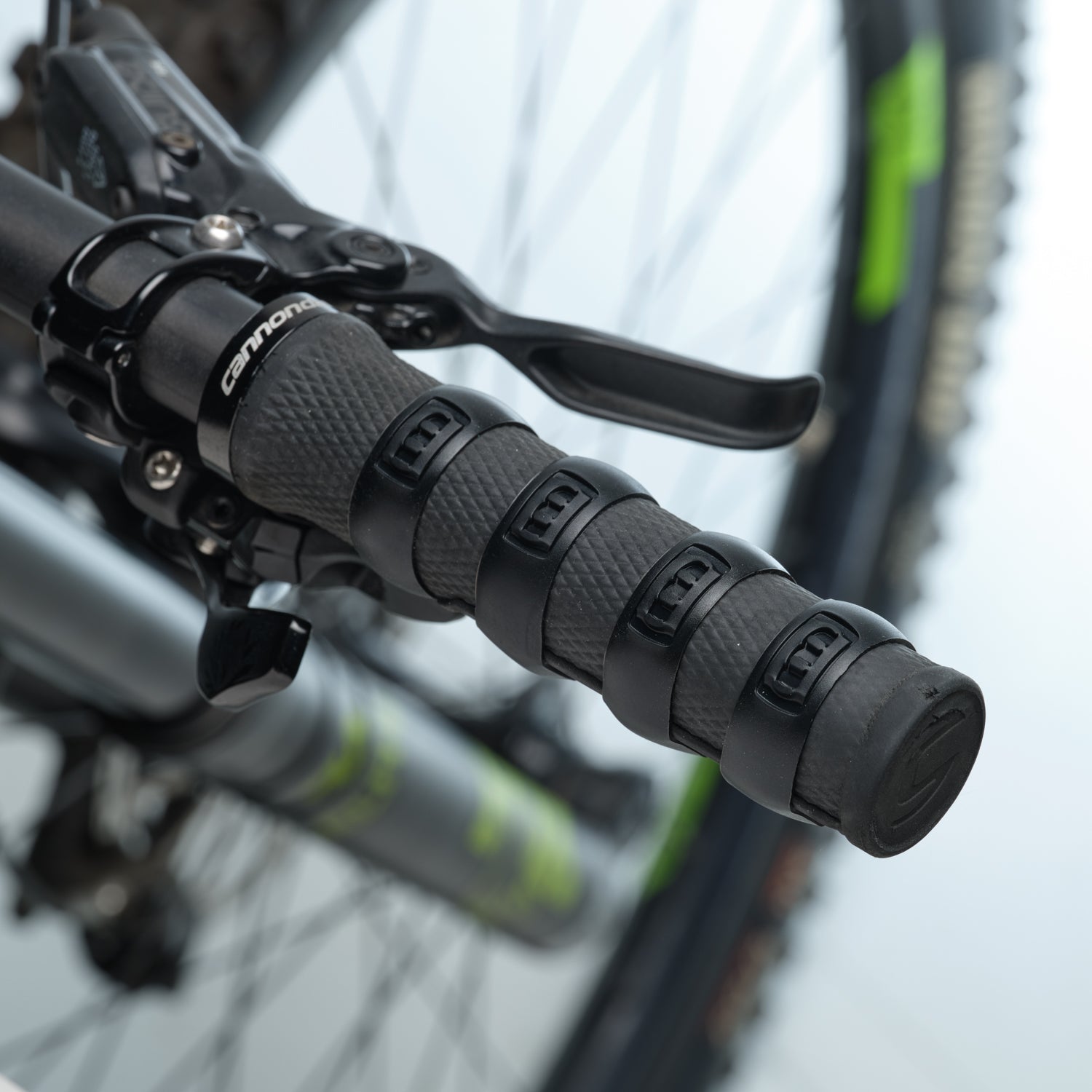Close-up of a bicycle handlebar with black Mint Sport silicon rings (aka SiliGrip Ringz) against a blurred background