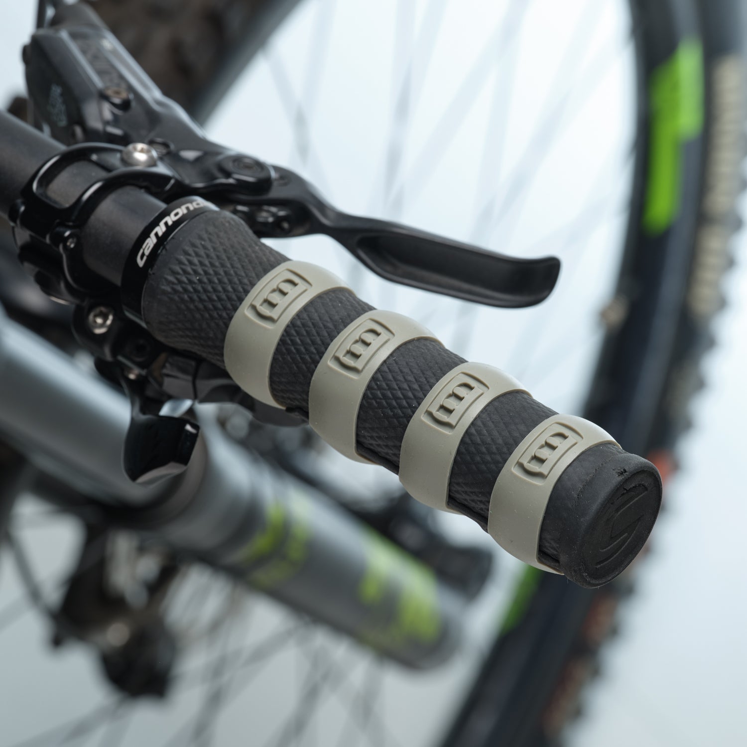Close-up of a bicycle handlebar with gray Mint Sport silicon rings (aka SiliGrip Ringz) against a blurred background