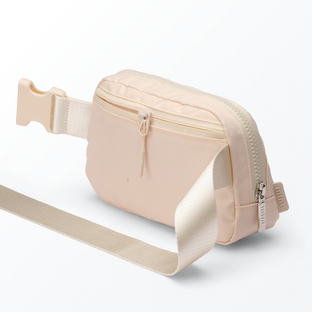 Studio image of a cream-colored Mint belt bag on a white background