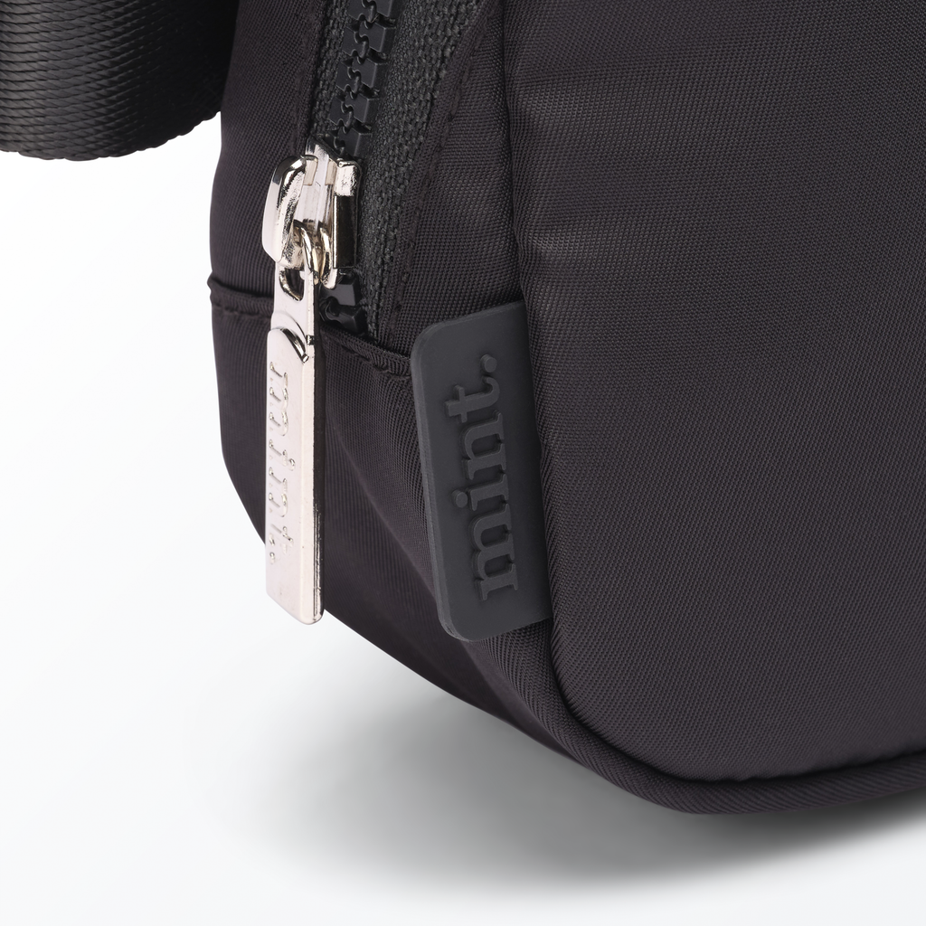 Close-up of a black-colored Mint Sport belt bag with a zipper on a white background