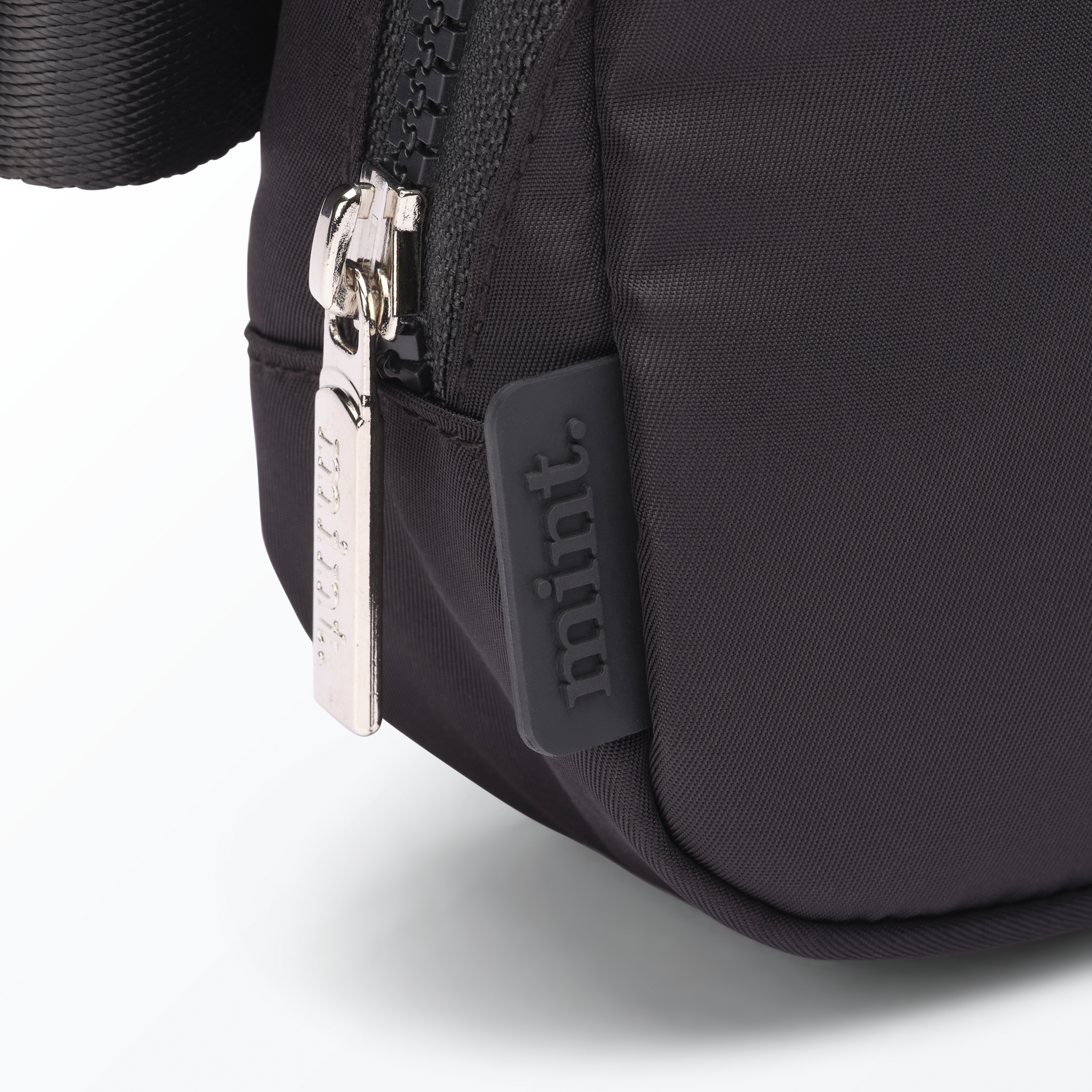 Close-up of a black-colored Mint Sport belt bag with a zipper on a white background