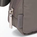 Close-up of a dark-gray-colored Mint Sport belt bag with a zipper on a white background