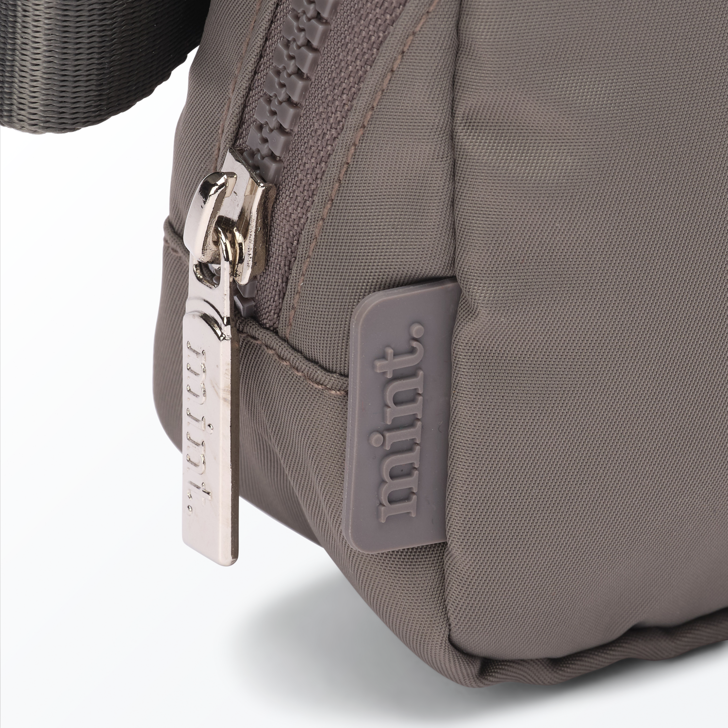 Close-up of a dark-gray-colored Mint Sport belt bag with a zipper on a white background