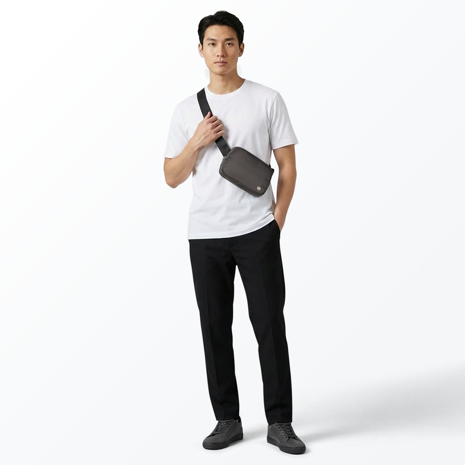 Man wearing a white t-shirt, black pants, and gray sneakers with a gray Mint Sport belt bag on a white background