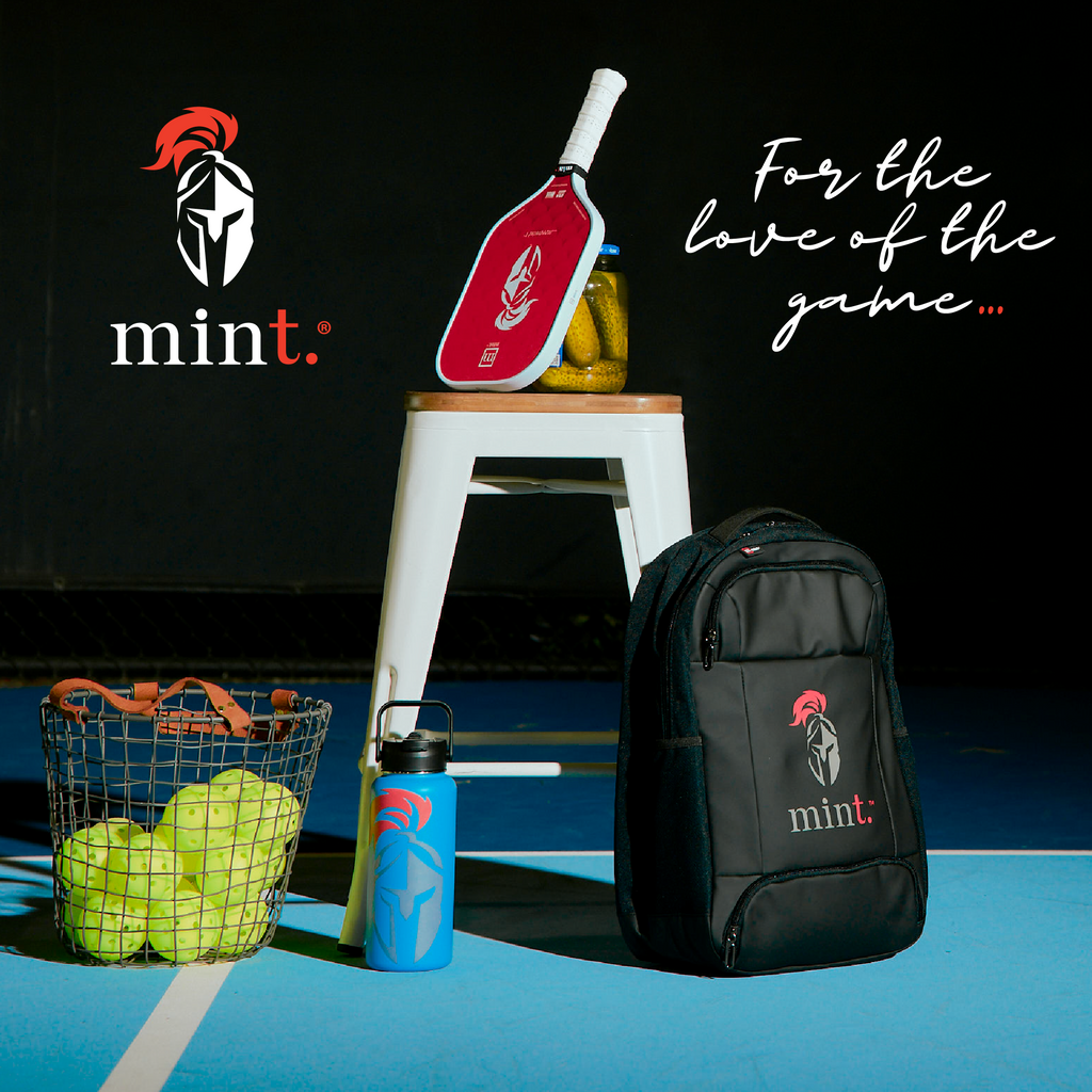 Paddle racket, backpack, and sports equipment on a court with 'mint' branding.