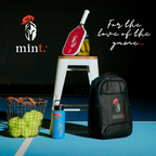 Paddle racket, backpack, and sports equipment on a court with 'mint' branding.