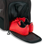Unleash Tournament Bag in Black, court shoes coming out of the bottom shoe compartment