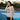 Woman wearing a gray tank top with a graphic design on an outdoor court
