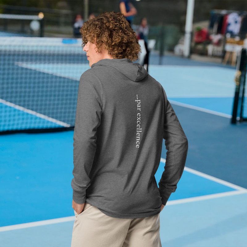 Person wearing a gray hoodie with 'par excellence' text on a tennis court