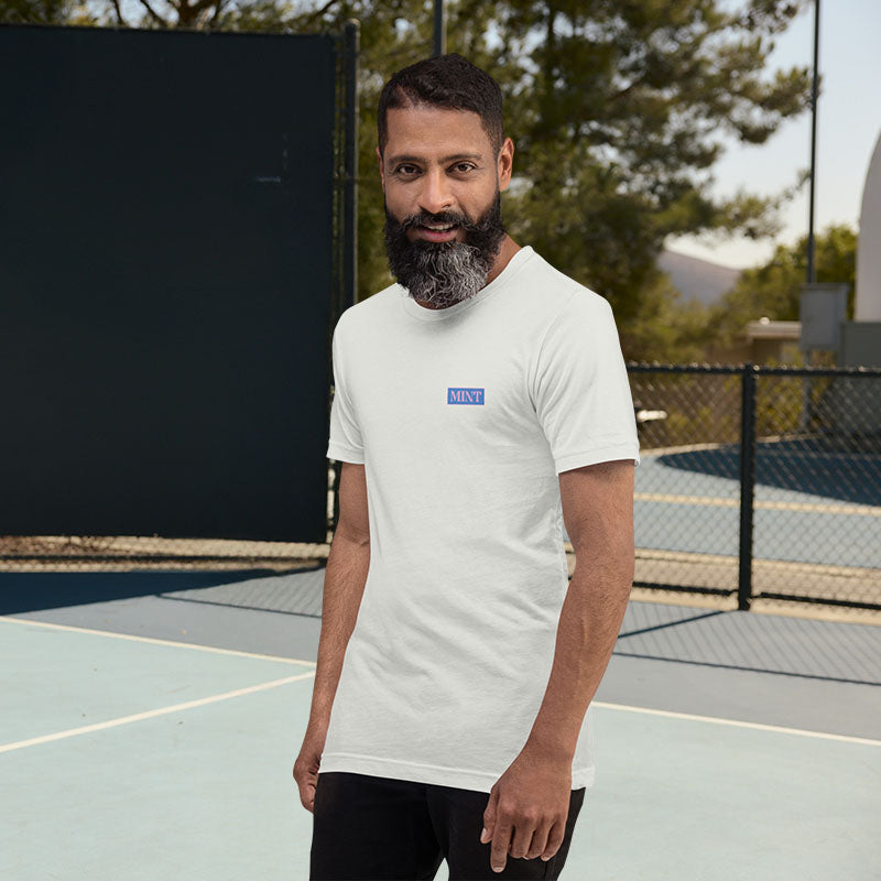 Man wearing a white t-shirt with a logo on a tennis court