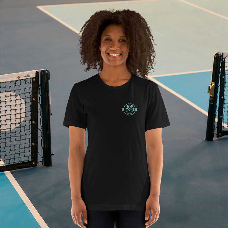 Person wearing a black t-shirt with a logo on a tennis court