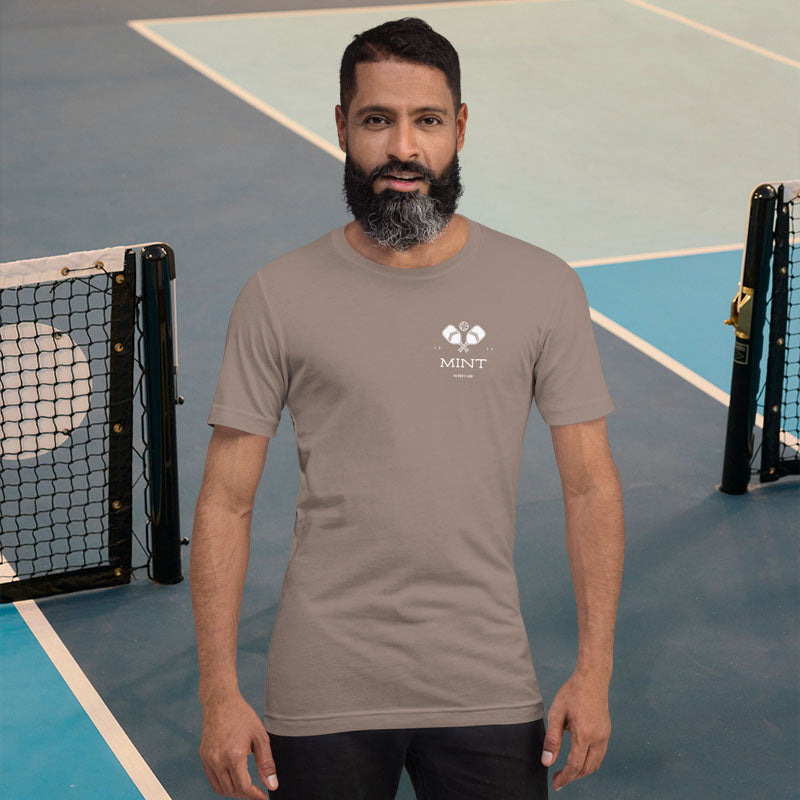 Man wearing a brown t-shirt with a logo on a tennis court