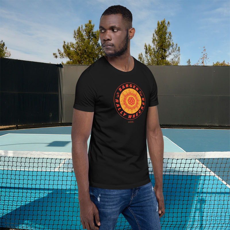 Man wearing a black t-shirt with a red and yellow graphic design standing in front of a pool.